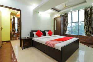 1 dormitorio con 1 cama grande con almohadas rojas en Hotel Sai Vatika Guest House, en Lucknow