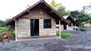 a small log cabin with a door in a yard at Chalés Vale do Rio do Boi in Praia Grande