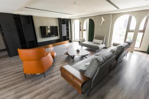 a living room with a couch and two chairs at Q21 Hotel in Kaohsiung
