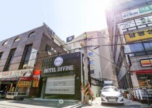 a city street with buildings and a car parked on the street at Gwangju Divine Hotel in Gwangju