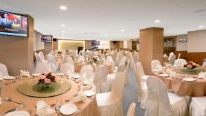a banquet hall with white tables and white chairs at E-RED HOTEL KUANTAN in Kuantan