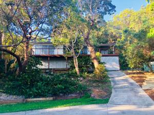 a house with a sidewalk in front of it at Billa Bush Cottage in Point Lookout