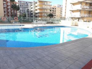 duży basen z błękitną wodą w budynku w obiekcie Infante II Primera Linea Playa De Gandia SOLO FAMILIAS w mieście Playa de Gandia