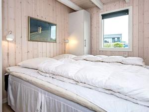 a large white bed in a room with a window at Three-Bedroom Holiday home in Hemmet 89 in Falen