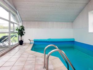 a swimming pool in a room with a large window at Four-Bedroom Holiday home in Gilleleje 1 in Gilleleje
