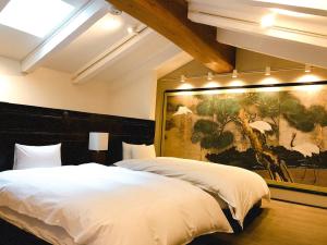 
a hotel room with a bed and a painting on the wall at Yamanoo Bettei Ryokusone in Kanazawa
