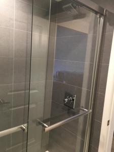 een douche met een glazen deur in de badkamer bij PASADENA LODGE in Pasadena