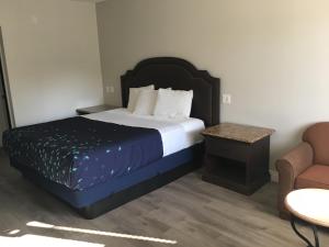 een hotelkamer met een bed en een stoel bij PASADENA LODGE in Pasadena