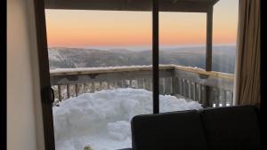 マウント・ホッサムにあるShamrock Apartment 4の窓付きの客室で、外に雪が降り注ぐ客室です。