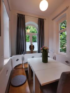 sala de estar con mesa blanca y 2 ventanas en Landhaus Haser, en Oberammergau