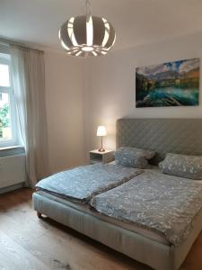 Un dormitorio con una cama grande y una lámpara de araña. en Landhaus Haser, en Oberammergau