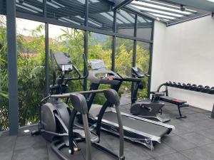 einen Fitnessraum mit zwei Cardiogeräten vor dem Fenster in der Unterkunft Bahang Bay Hotel in Batu Feringgi