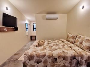 a bedroom with a bed and a flat screen tv at SLEEP TIGHT at Chumphon in Chumphon