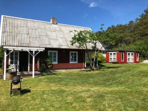a red and black house with a yard at Sarapuu puhkemaja in Hullo