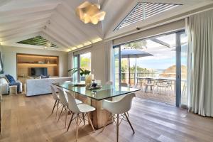 a dining room and living room with a table and chairs at Rock Villa in Cape Town