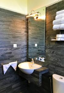 La salle de bains est pourvue d'un lavabo, d'un miroir et de toilettes. dans l'établissement Arena Hotel, à Beruwala
