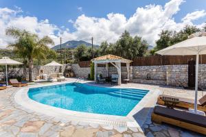 a swimming pool with a gazebo and a villa at Villa Angeliki in Lévktron