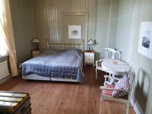 een slaapkamer met een bed en twee tafels en twee stoelen bij Siaröfortet Skärgårdskrog och Pensionat in Norra Ljustero