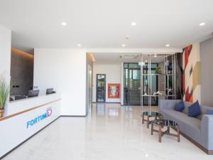 an office lobby with a couch and a table at Fortune D Hotel Phitsanulok in Phitsanulok