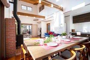 a dining room with a large wooden table with chairs at Guest house Japan Kita-Karuizawa in Saikubo