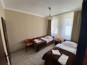 una habitación de hotel con 2 camas y una silla en Hotel Morze en Ustka