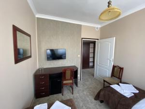 a hotel room with a desk and a bedroom at Hotel Morze in Ustka