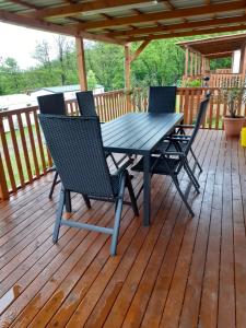 una terraza de madera con mesa y sillas. en Mobilheim Josefína - Výrovická přehrada, en Výrovice