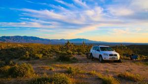 a white car parked in a field with a rainbow in the background at Dry Camping, Bring your own Camping Gear, RV or Mobile, close to sand dunes in Salome