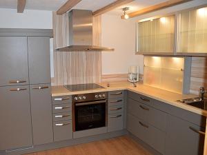 cocina con armarios grises y horno con fogones en Haus Wiesengrund-Fahl - FeWo 4, en Todtnau