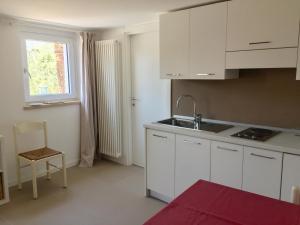 a kitchen with white cabinets and a sink and a window at Casa Mary in Brenzone sul Garda
