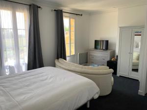 a bedroom with a bed and a chair and a dresser at Le Melchior in Sainte-Terre +36 photos