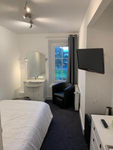 a hotel room with a bed and a chair and a sink at Le Melchior in Sainte-Terre