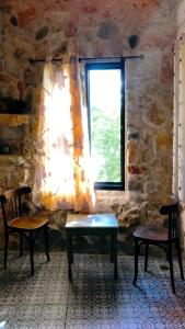 a room with two chairs and a window at Zimer Al-Bayt in Mas'ade