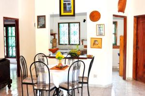 une salle à manger avec une table et des chaises blanches dans l'établissement Surewo Sun Shine Apartment, à Bentota