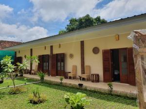 een huis met houten deuren en een tuin bij Naima Jiwo in Yogyakarta