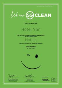 een groene hoteluitnodiging met een smiley bij Hotel Yan in Singapore