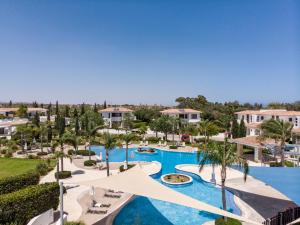an aerial view of a resort pool with palm trees at Atlantis Gardens in Mazotos