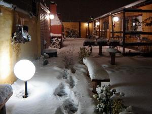 a yard covered in snow with benches and lights at De a Dos in San Rafael
