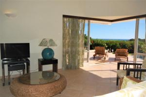 a living room with a tv and a couch and a table at Vila Rosa - Private Swimming Pool With Sea View in Albufeira