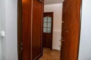 korytarz z otwartymi drewnianymi drzwiami i lustrem w obiekcie Apartament Jasna Plaża w Jastrzębiej Górze