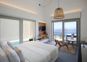 a bedroom with a bed and a view of the ocean at Melidonia Suites in Akrotiri