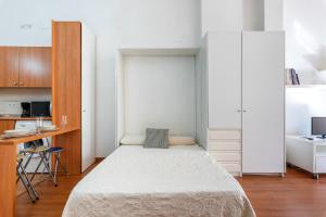 Habitación pequeña con cama y escritorio. en Apartamento centro historico, en Málaga