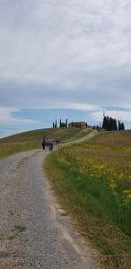 een groep mensen die over een onverharde weg lopen bij Staffolino in Siena