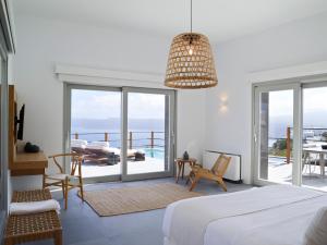 a room with a bed, a chair, and a window at Melidonia Suites in Akrotiri