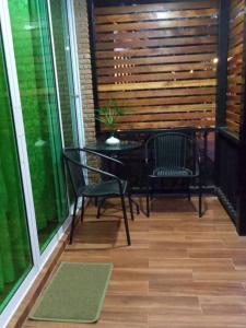 une terrasse couverte avec 2 chaises et une table. dans l'établissement Baan B&B Sukhothai, à Sukhothaï