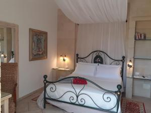 a bedroom with a white bed with a black frame at Masseria L'Uliveto Agri Resort in Otranto