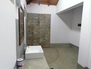 a bathroom with a sink and a stone wall at Ladja Beach Resort in Ambalantota