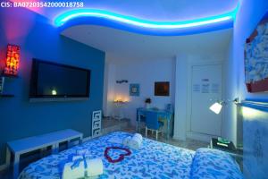 a blue room with a bed and a tv at Versomare in Polignano a Mare