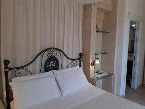 a bedroom with a white bed with a black headboard at Masseria L'Uliveto Agri Resort in Otranto