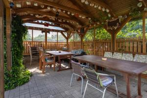 a wooden pavilion with tables and chairs on a patio at Pension Vetrny Vrch in Ostrov